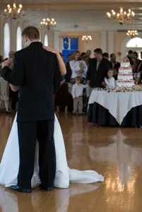 Bride and groom having a first dance in front of their cake